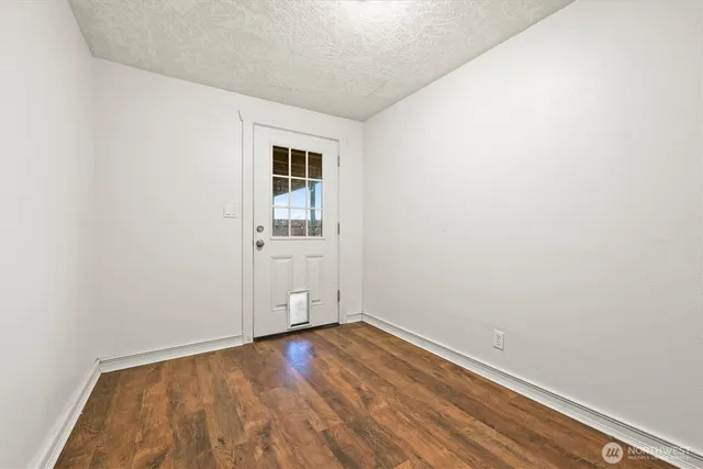 a view of a room with wooden floor and white walls