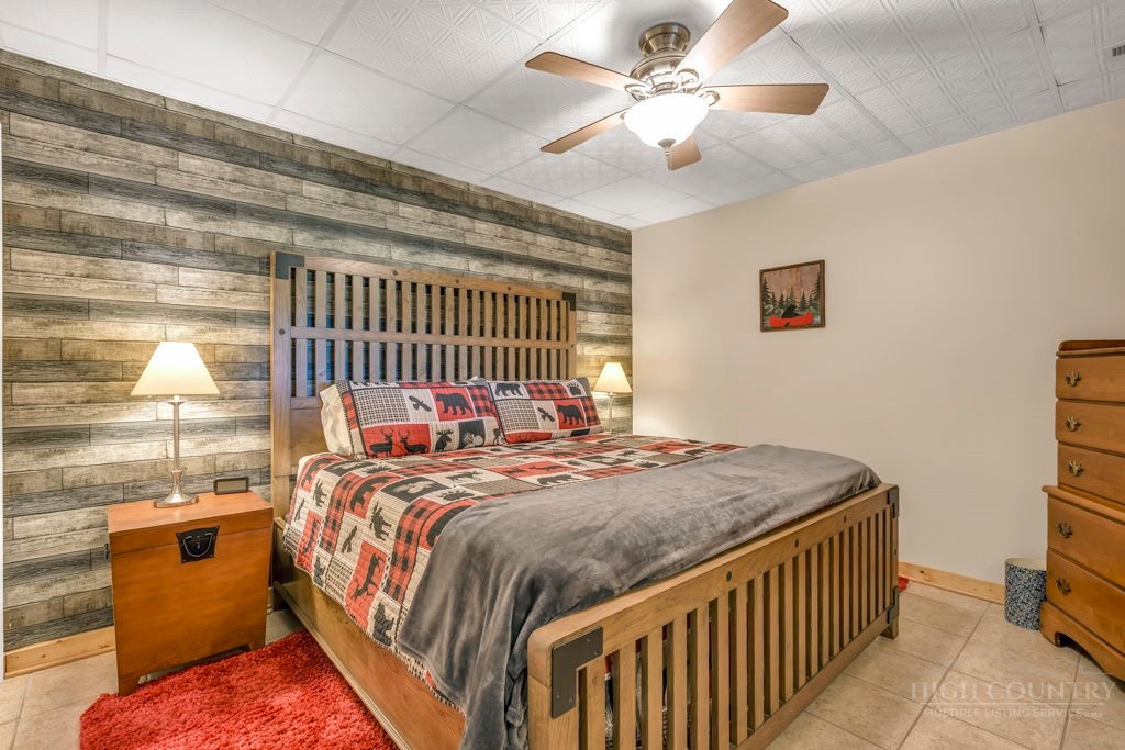 2229 Elk Ridge Road Ferguson, NC 28624 - Photo 37 of 42 a bedroom with a bed and a chandelier
