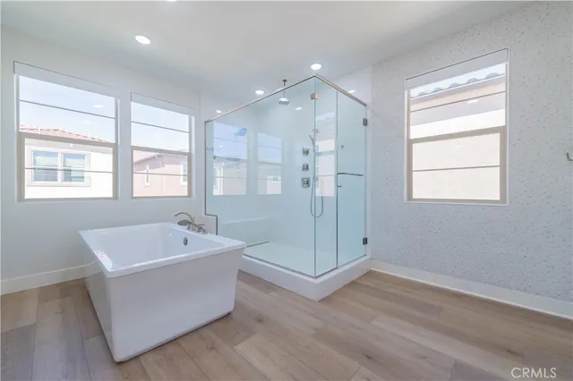 a spacious bathroom with a tub sink shower and mirror