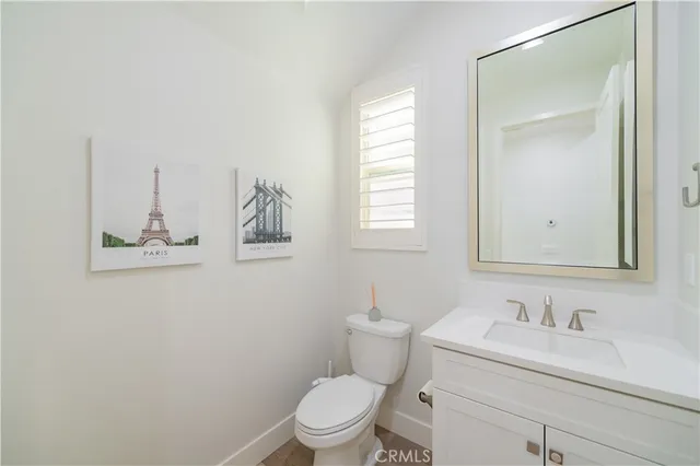 a bathroom with a toilet sink vanity and mirror