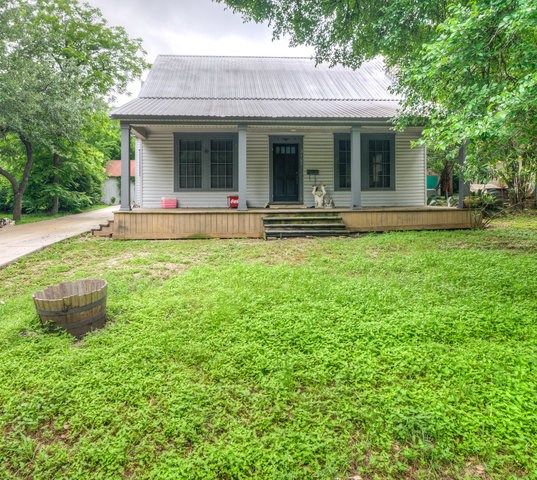 a view of a house with backyard and porch