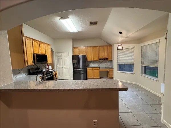 a view of living room with kitchen island furniture and a flat screen tv
