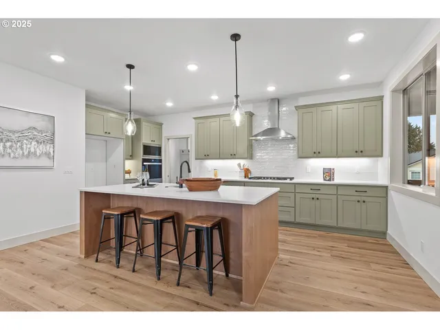 a kitchen with stainless steel appliances kitchen island granite countertop a sink stove and cabinets