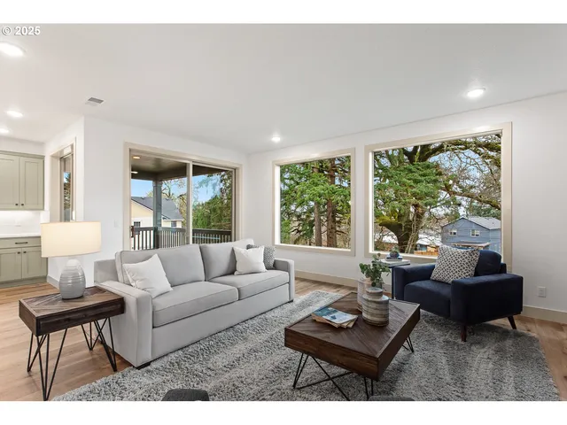 a living room with furniture kitchen view and a large window