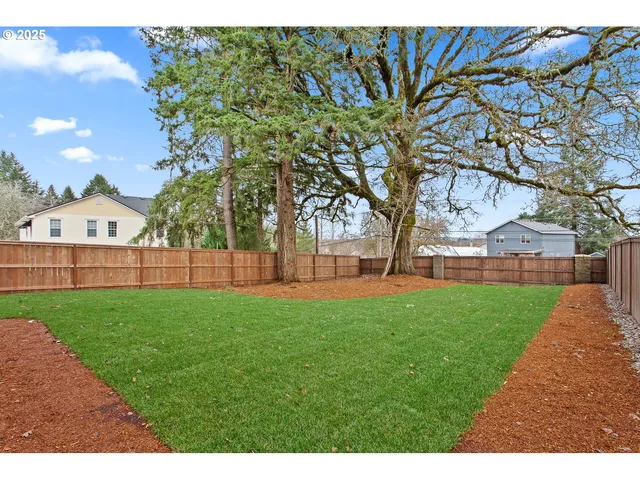 a view of a backyard with a garden and trees