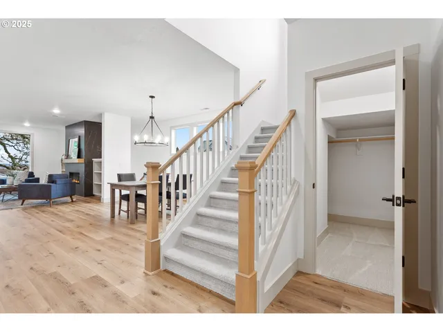 a view of a dining room and livingroom with furniture wooden floor a chandelier