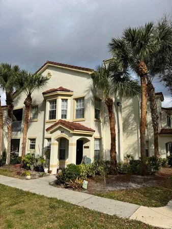 a front view of a house with yard and parking