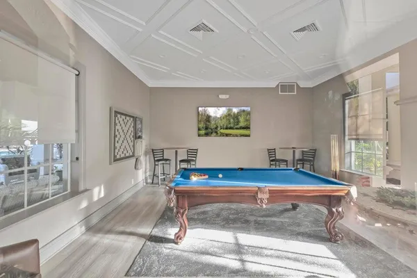 a room with pool table and windows