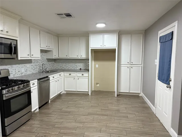 a kitchen with white cabinets and white appliances
