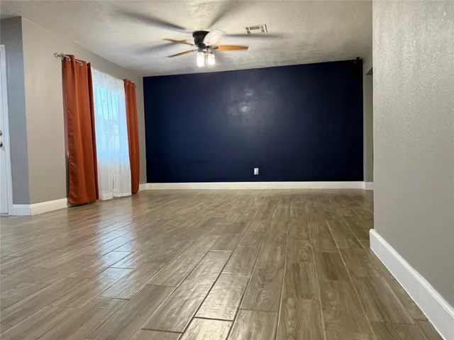 a view of an empty room with wooden floor