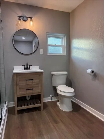 a bathroom with a toilet a sink and mirror