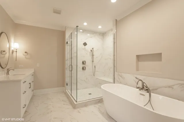 a bathroom with a tub sink shower and mirror