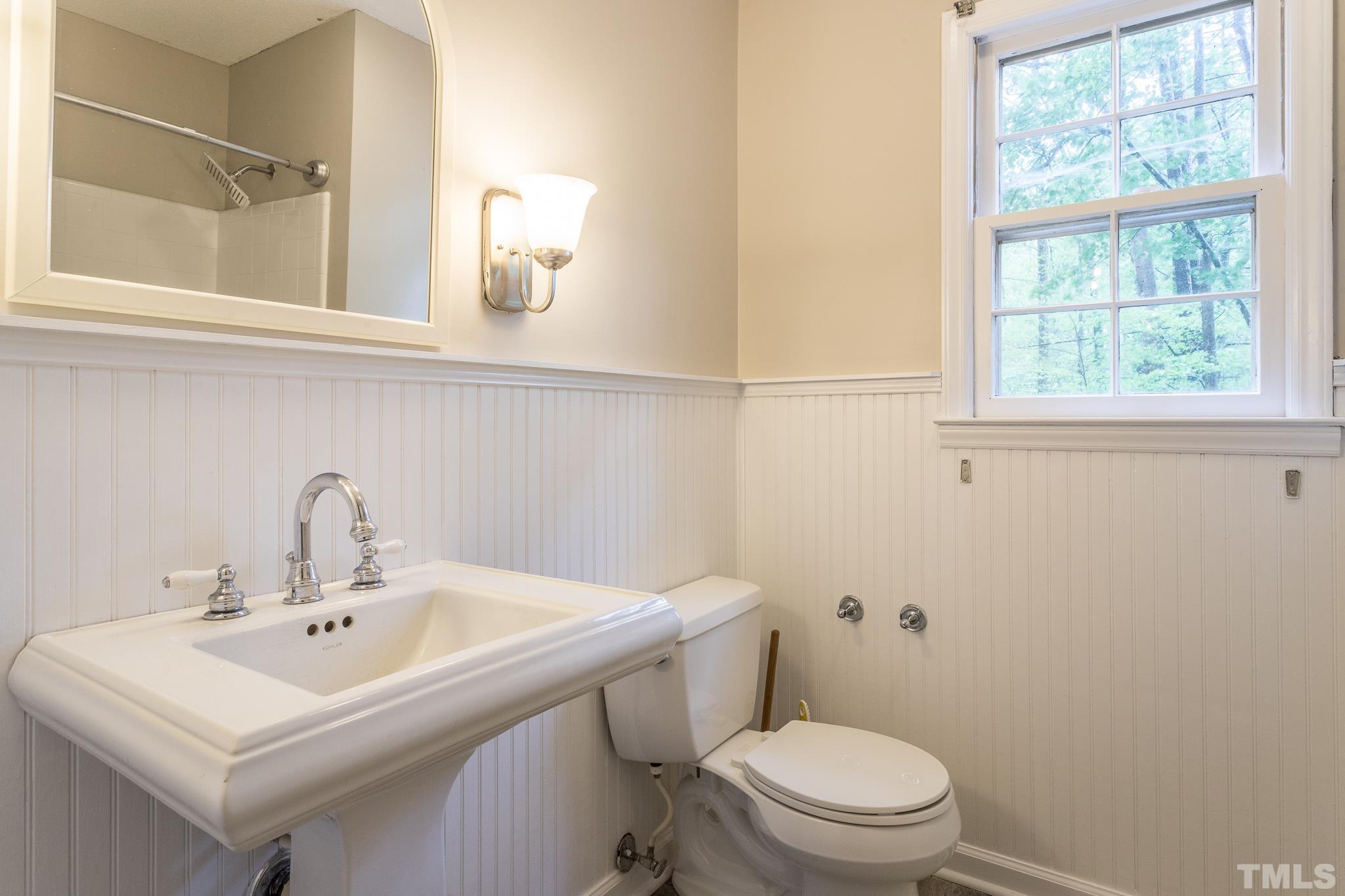 6216 Garrett Road Raleigh, NC 27606 - Photo 17 of 25 a bathroom with a sink a toilet and a mirror
