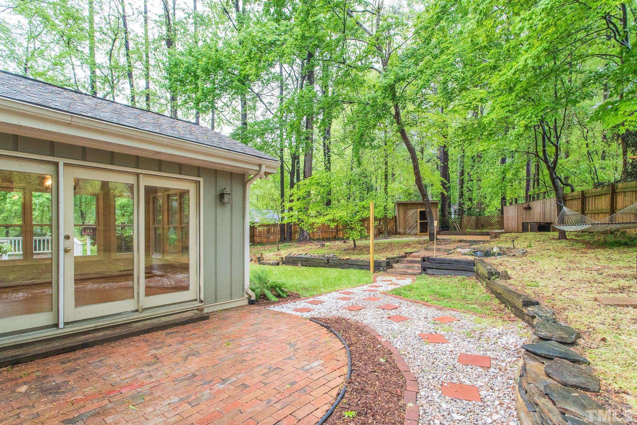 6216 Garrett Road Raleigh, NC 27606 - Photo 22 of 25 a view of a house with backyard and sitting area