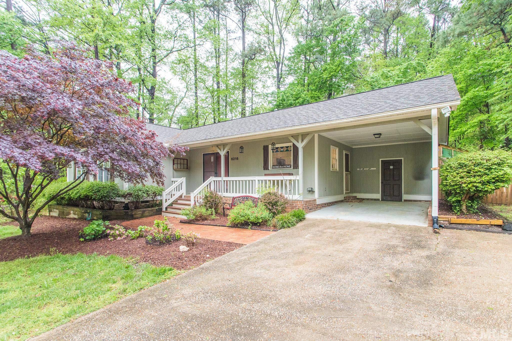 6216 Garrett Road Raleigh, NC 27606 - Photo 5 of 25 a front view of a house with a yard and potted plants