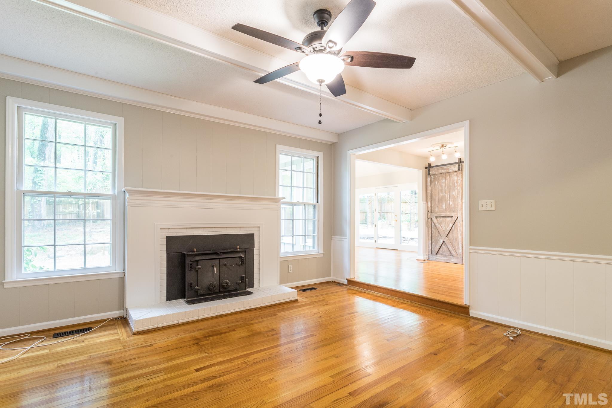 6216 Garrett Road Raleigh, NC 27606 - Photo 7 of 25 wooden floor fireplace and windows in an empty room