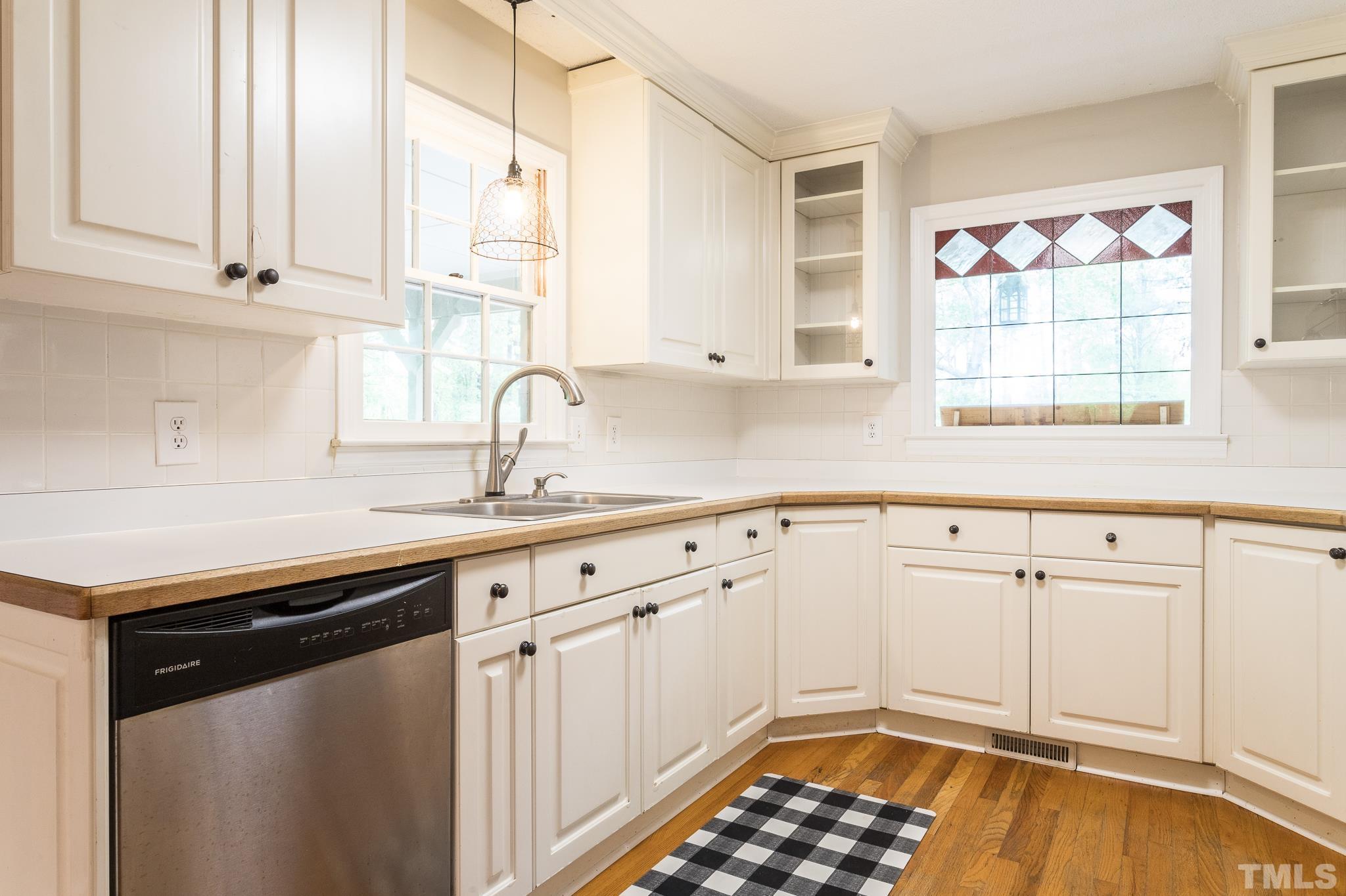 6216 Garrett Road Raleigh, NC 27606 - Photo 9 of 25 a kitchen with granite countertop a sink stainless steel appliances white cabinets and a window