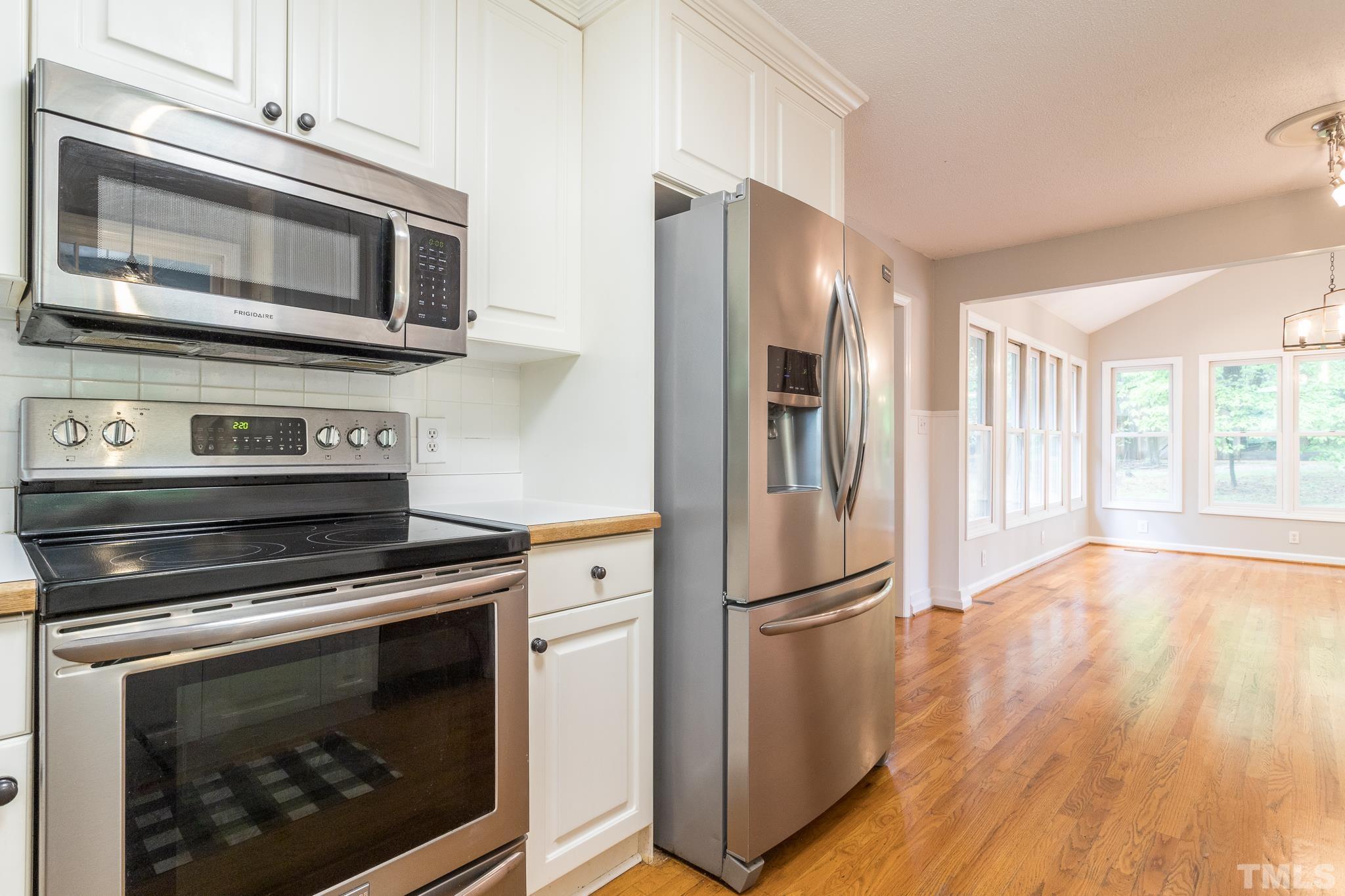 6216 Garrett Road Raleigh, NC 27606 - Photo 10 of 25 a kitchen with granite countertop a refrigerator stove and microwave