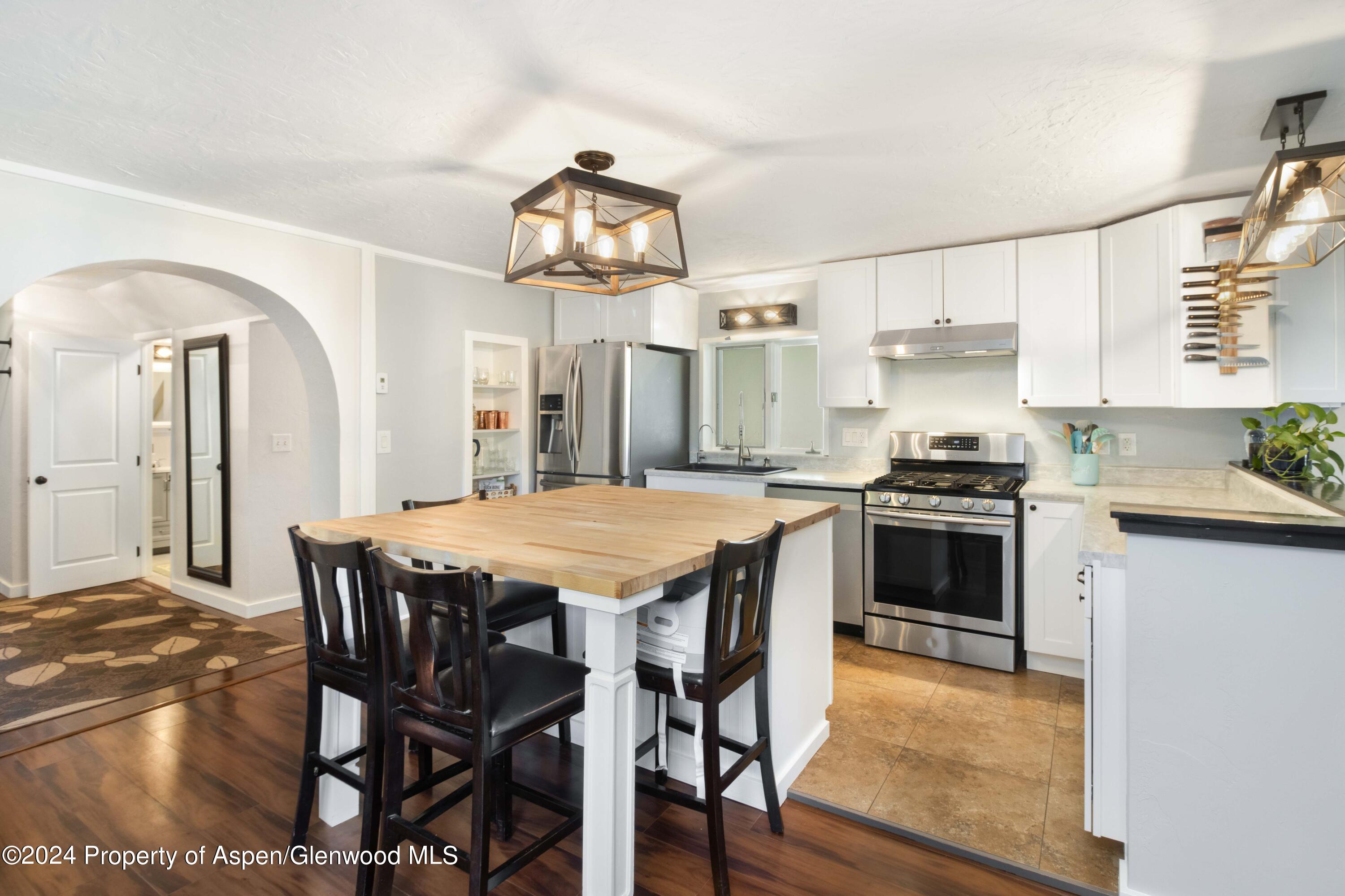 816 East 2nd Street New Castle, CO 81647 - Photo 12 of 32 a kitchen with a table chairs stove and cabinets