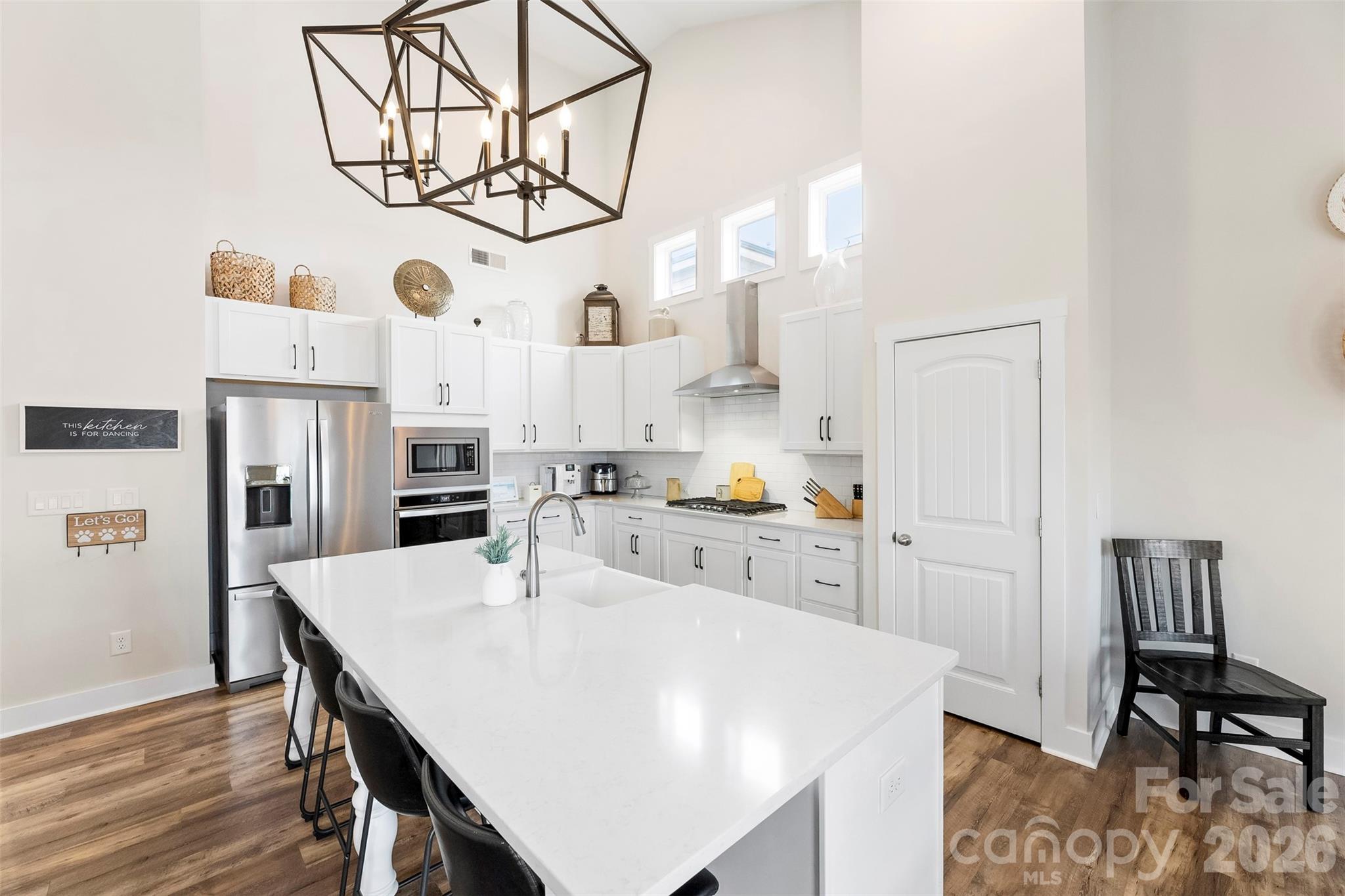 6283 Six String Court Fort Mill, SC 29708 - Photo 16 of 40 a kitchen with stainless steel appliances a white table chairs and a refrigerator