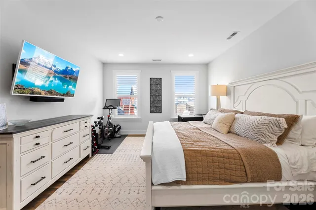 a bedroom with a bed a computer on the desk and chair