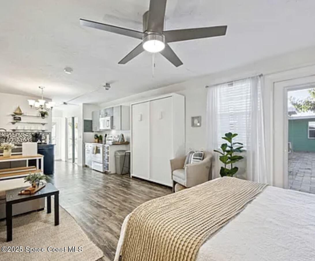 105 Northeast 3rd Street, Unit AD Satellite Beach, FL 32937 - Photo 13 of 27 a bedroom with a bed dresser and a view of kitchen