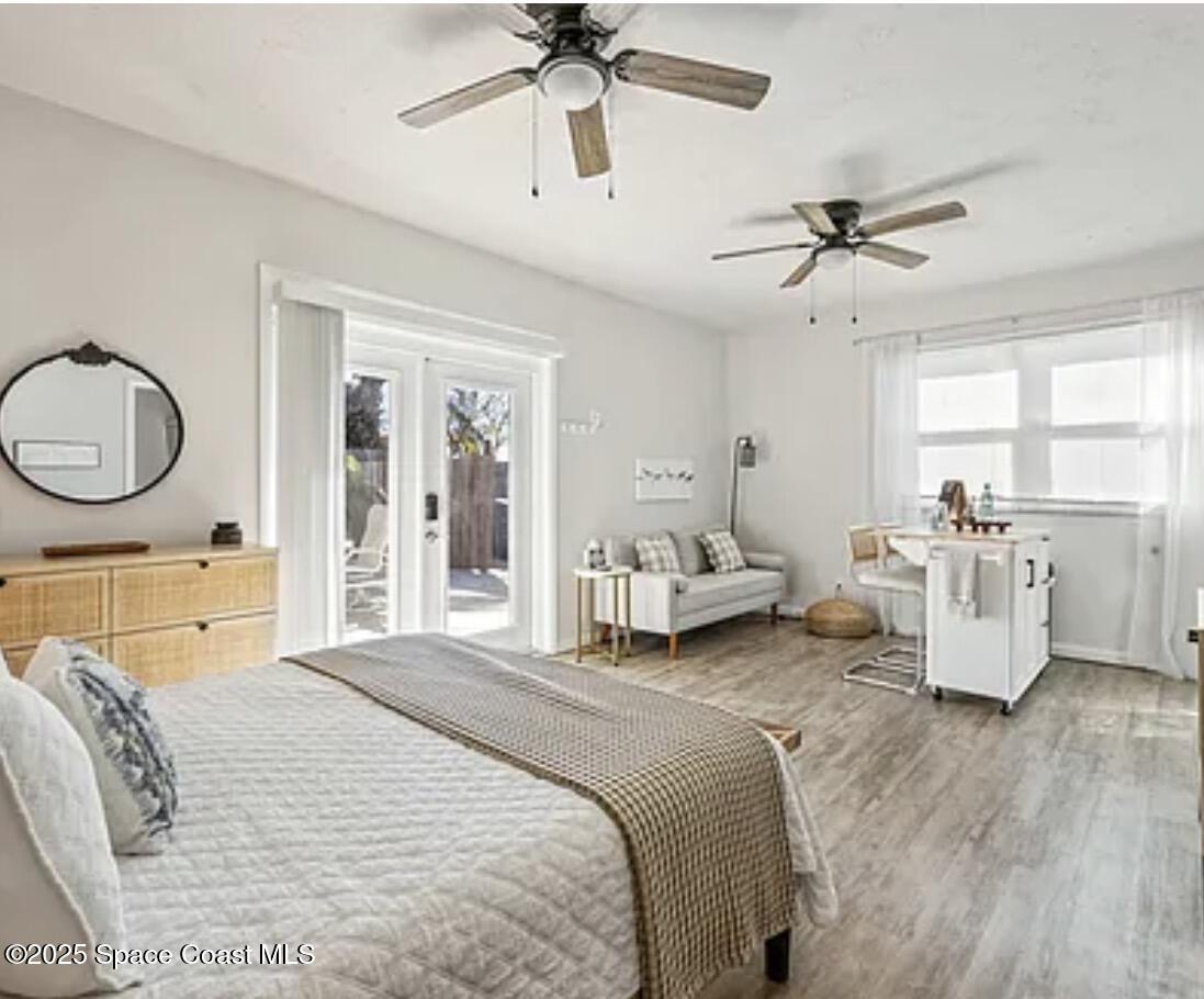 105 Northeast 3rd Street, Unit AD Satellite Beach, FL 32937 - Photo 14 of 27 a spacious bedroom with a bed a chandelier and a chandelier