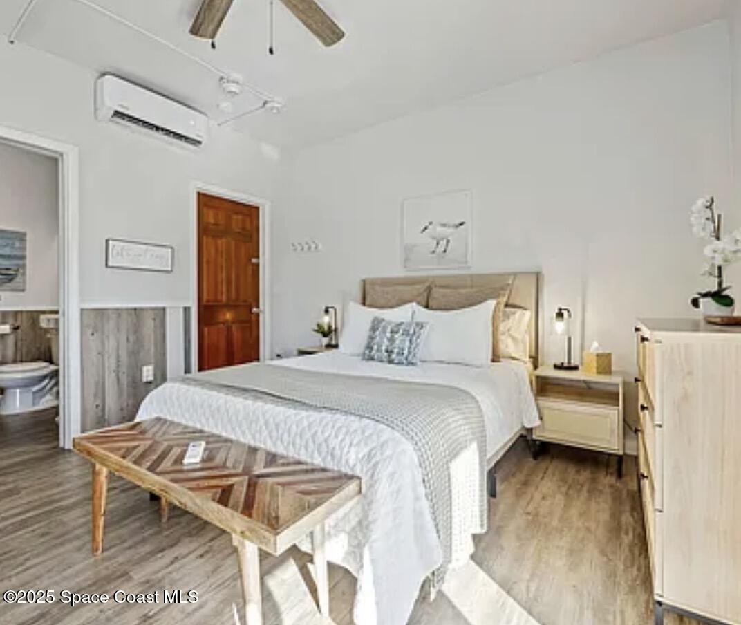 105 Northeast 3rd Street, Unit AD Satellite Beach, FL 32937 - Photo 17 of 27 a bedroom with a bed and wooden floor