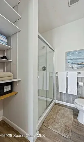 a bathroom with a glass shower door and a toilet