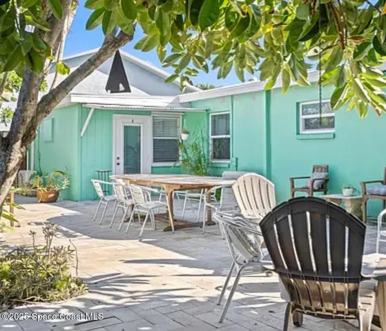 a view of a patio with table and chairs with wooden floor and fence