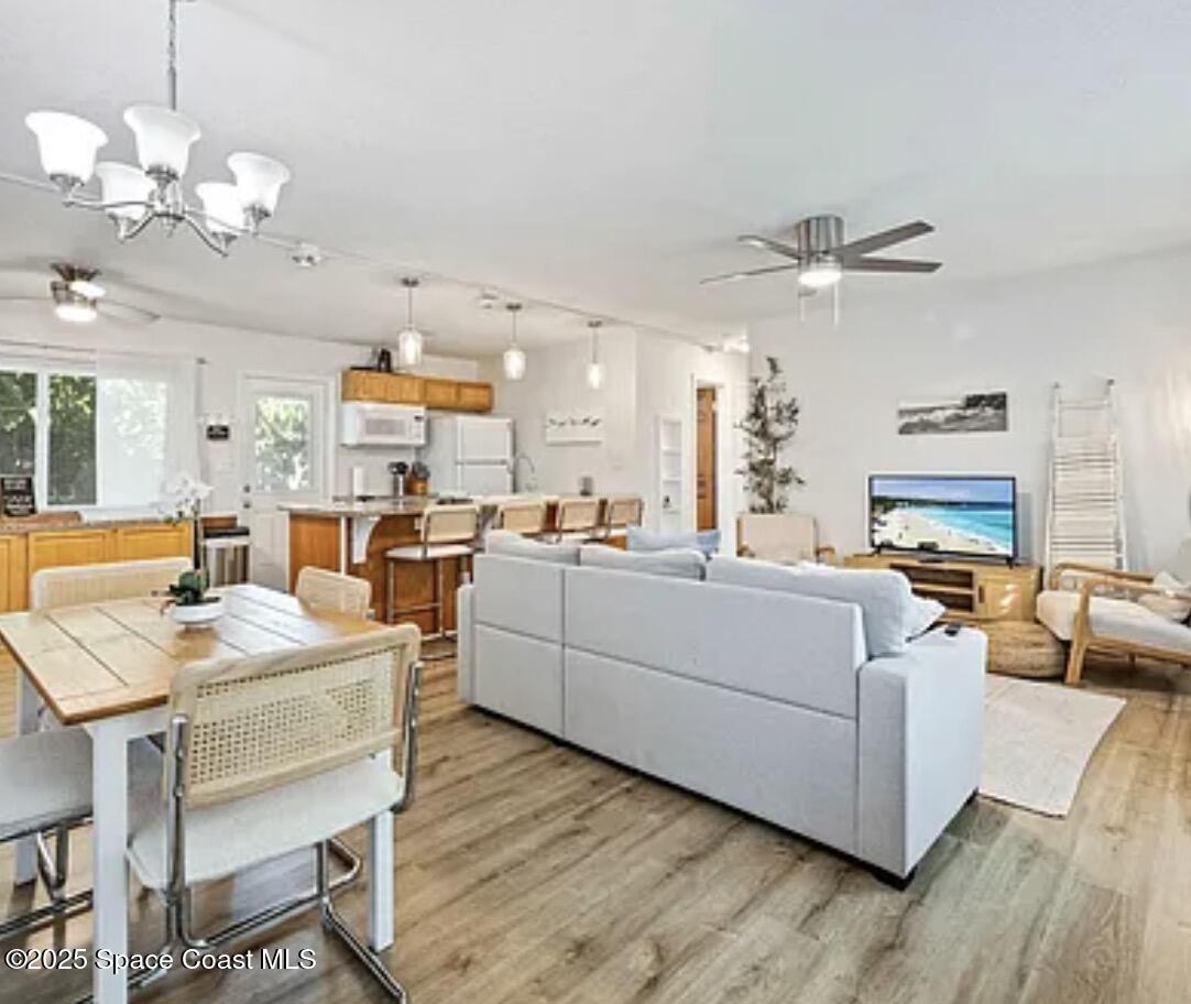 105 Northeast 3rd Street, Unit AD Satellite Beach, FL 32937 - Photo 23 of 27 a living room with furniture kitchen view and a chandelier