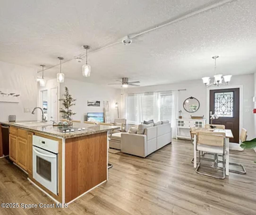 105 Northeast 3rd Street, Unit AD Satellite Beach, FL 32937 - Photo 5 of 27 a kitchen with a stove and a wooden floor