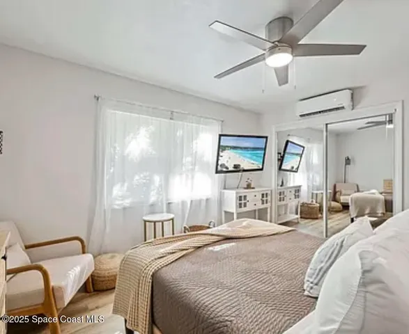 a bedroom with a bed couch and large window