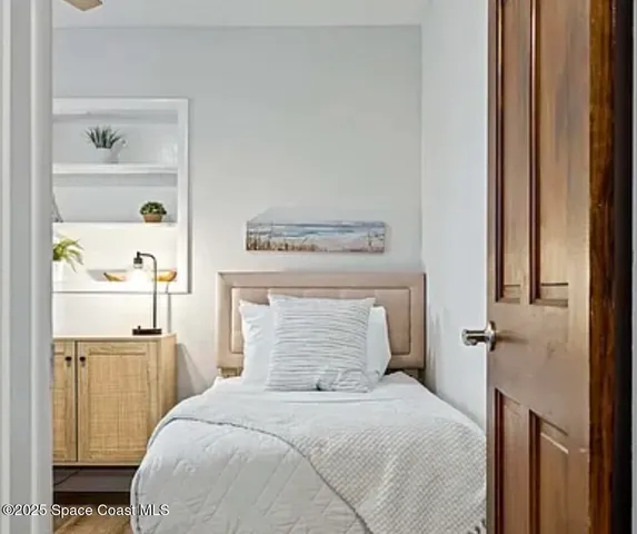 a bedroom with a bed and wooden floor
