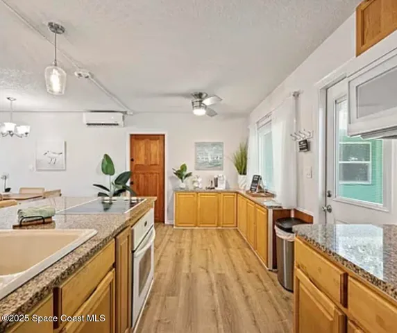 a large white kitchen with a large window a sink and stainless steel appliances