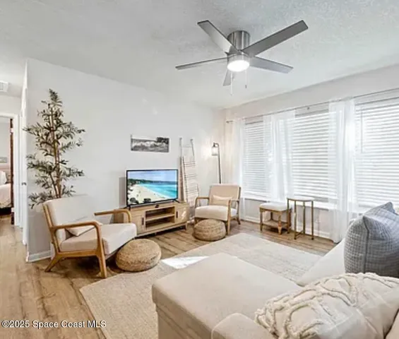 a living room with furniture large window and a chandelier