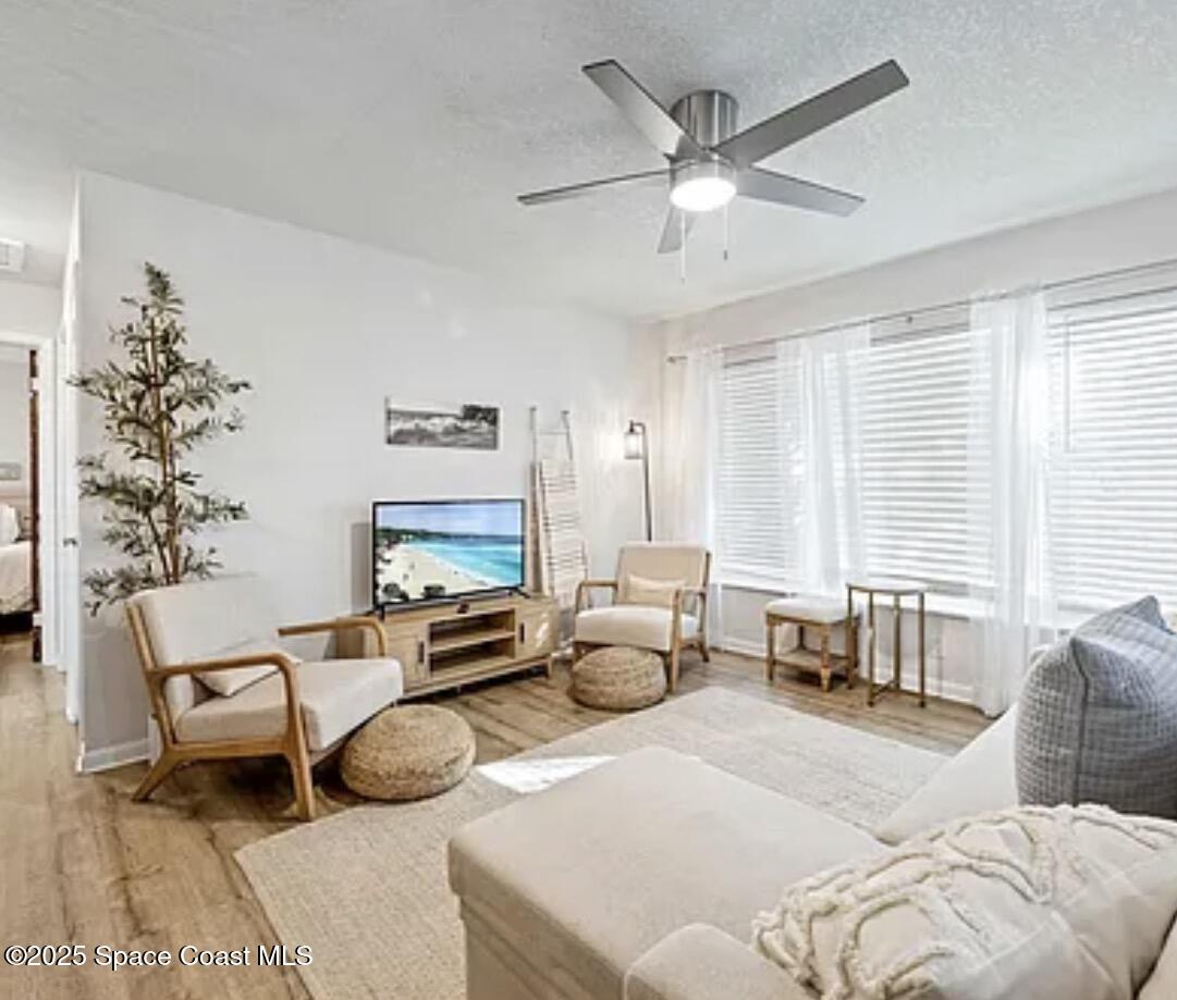105 Northeast 3rd Street, Unit AD Satellite Beach, FL 32937 - Photo 10 of 27 a living room with furniture large window and a chandelier