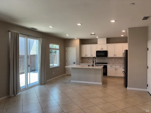 a kitchen with stainless steel appliances a refrigerator and a stove top oven