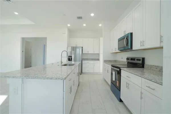 a kitchen with white cabinets and stainless steel appliances