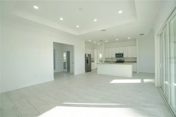 a view of kitchen with stainless steel appliances refrigerator oven and white cabinets