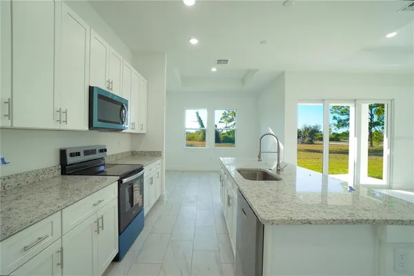 a kitchen with granite countertop a sink and a stove top oven