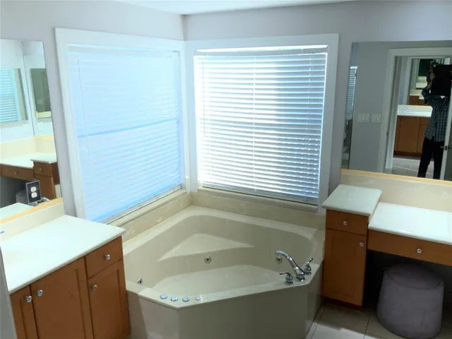 a bathroom with a tub sink and a mirror
