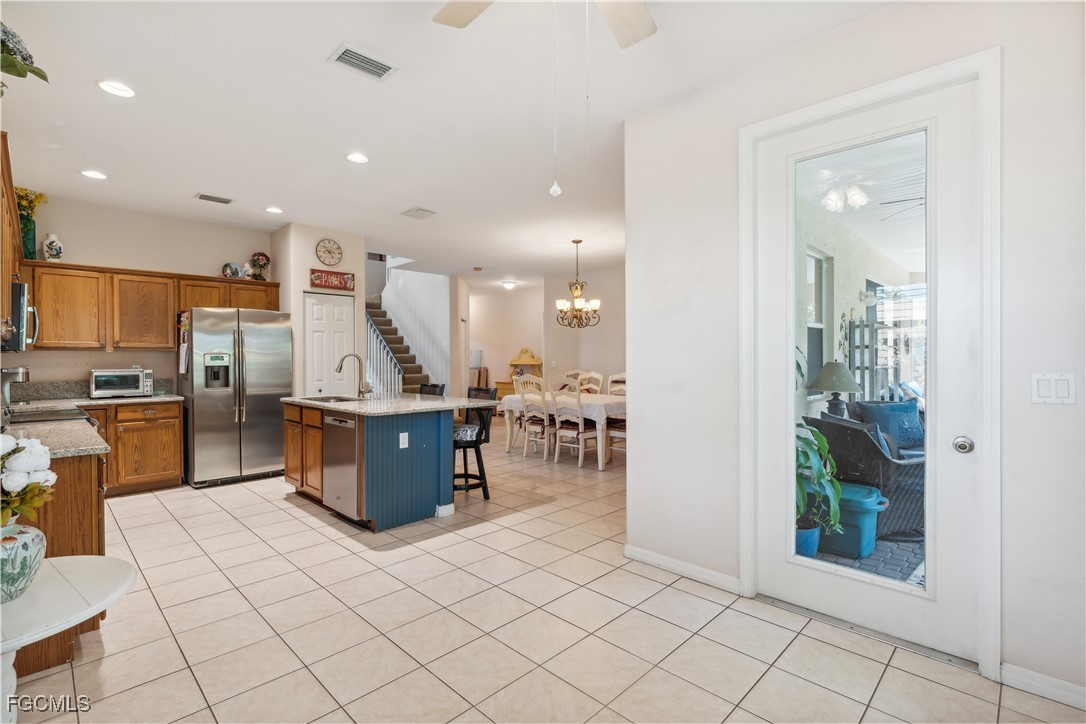 9475 Silver Pine Loop Fort Myers, FL 33967 - Photo 11 of 34 a view of kitchen with stainless steel appliances kitchen island granite countertop a refrigerator and a sink