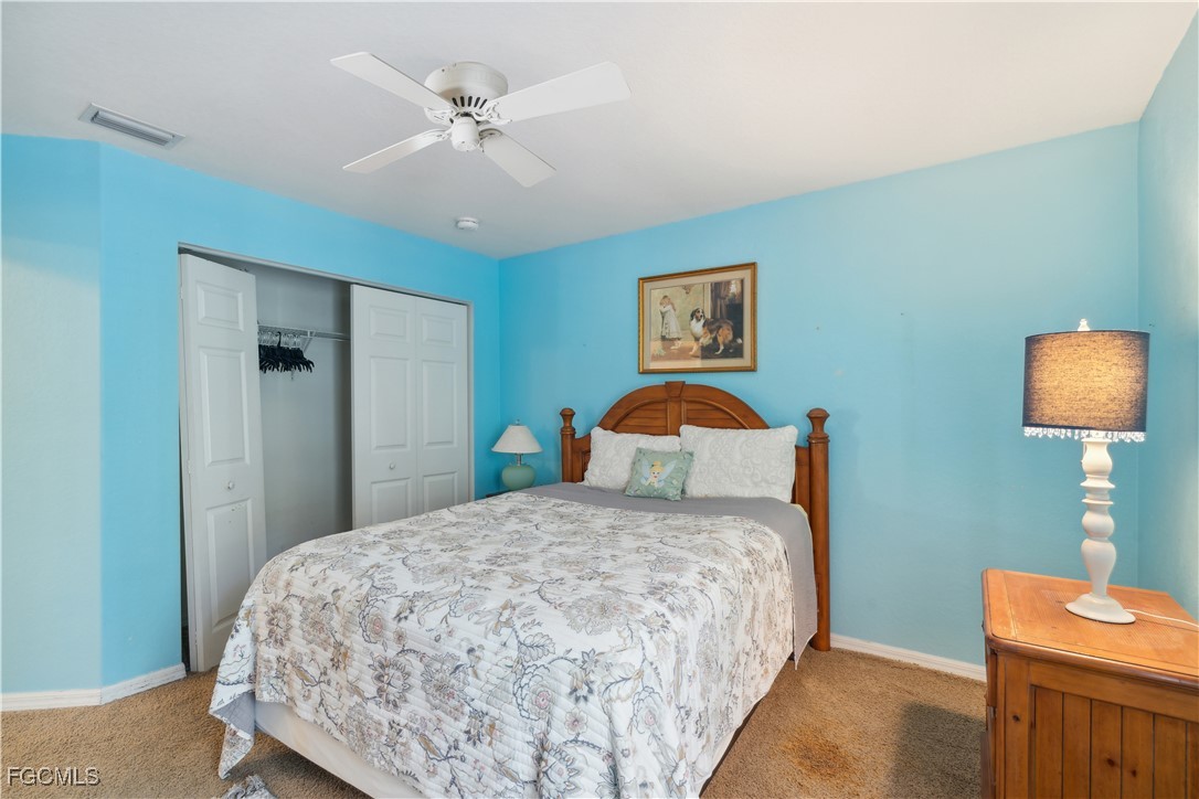 9475 Silver Pine Loop Fort Myers, FL 33967 - Photo 18 of 34 a bedroom with a bed and a chandelier