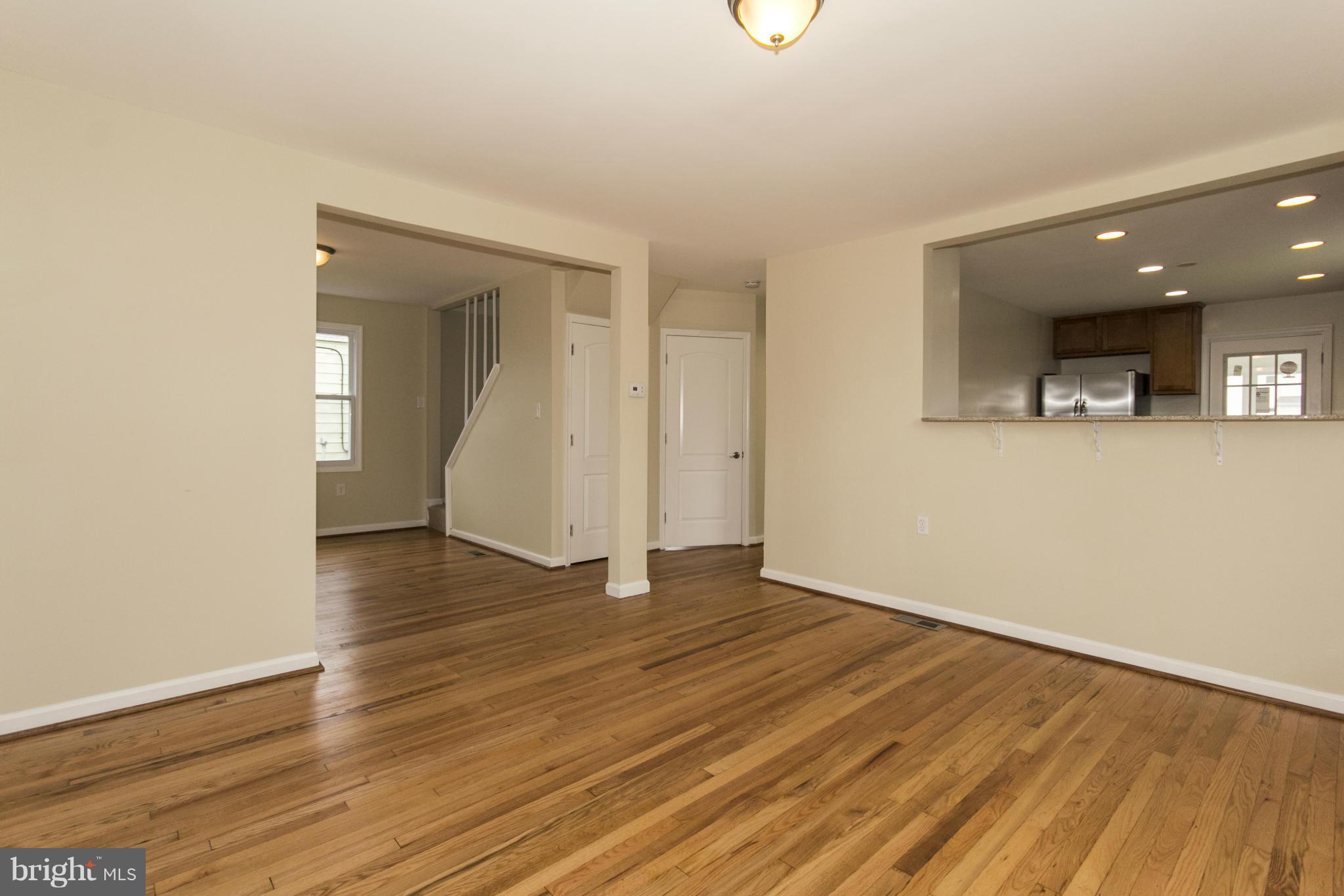 1220 Willow Road Baltimore, MD 21222 - Photo 2 of 23 an empty room with wooden floor and mirror