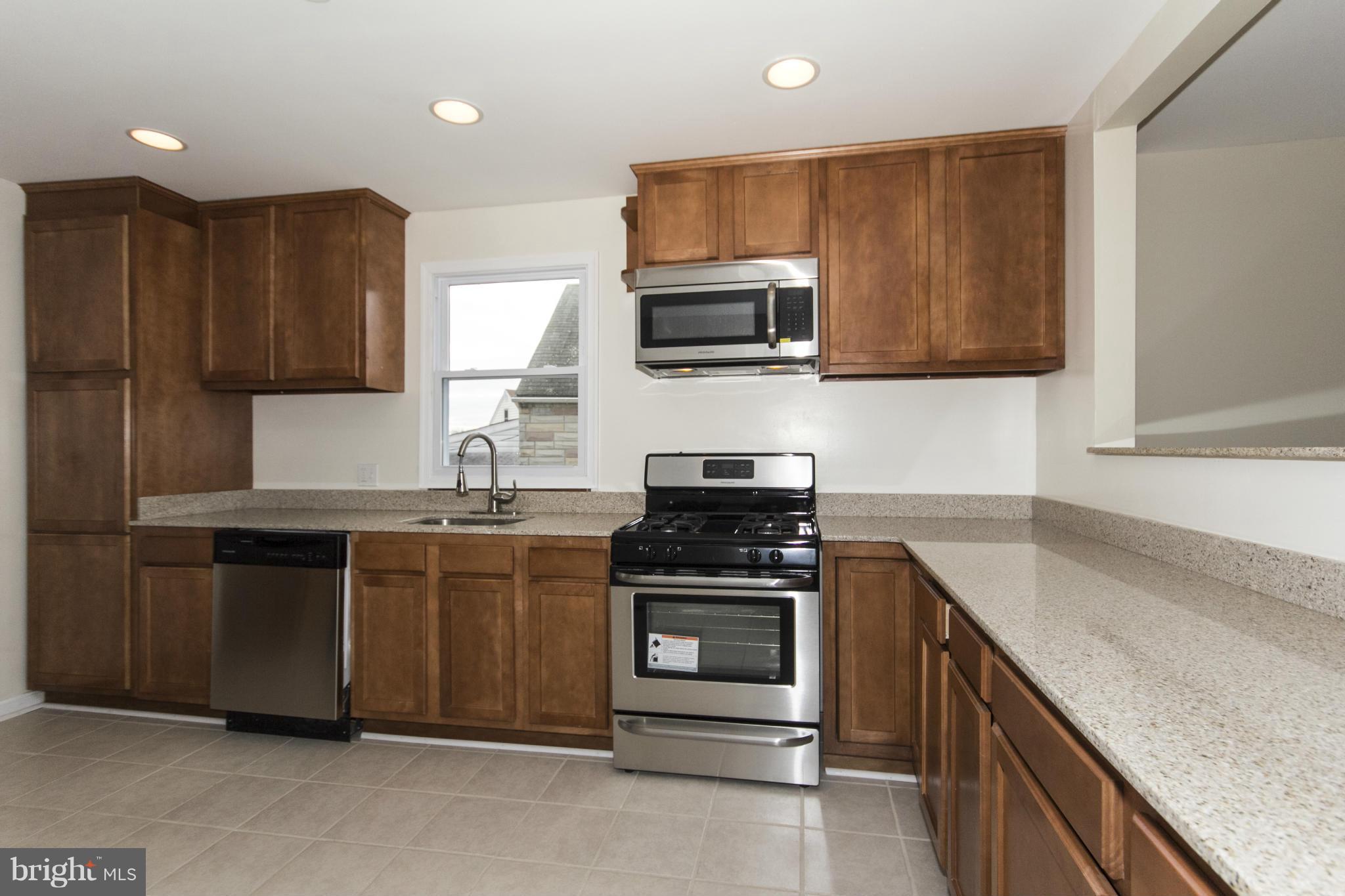 1220 Willow Road Baltimore, MD 21222 - Photo 12 of 23 a kitchen with stainless steel appliances granite countertop a stove a sink and a microwave