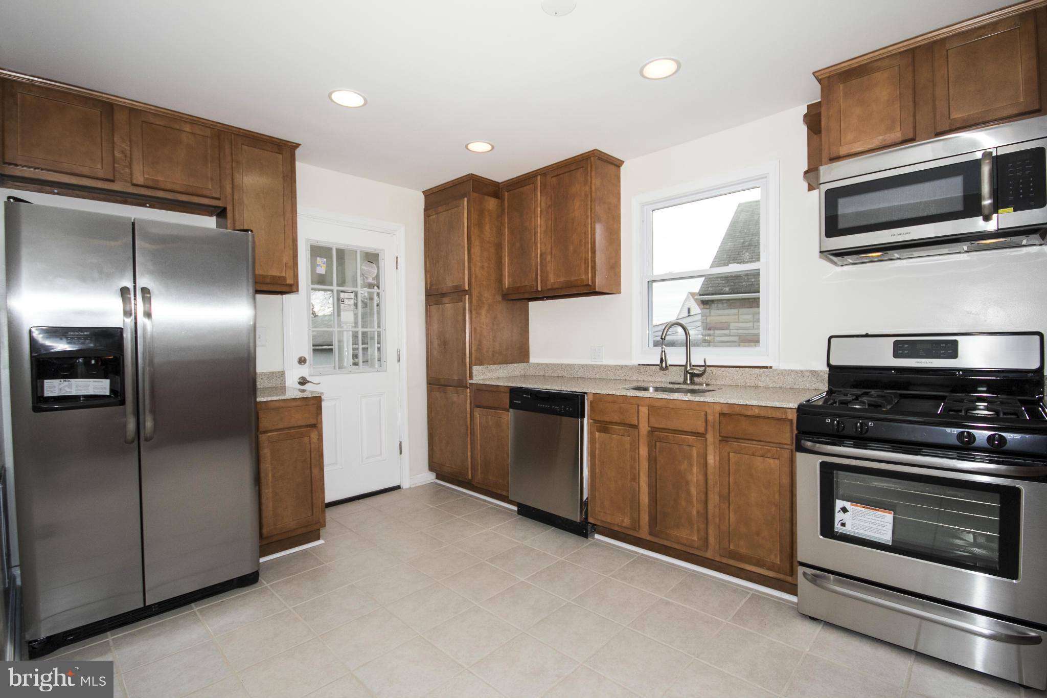 1220 Willow Road Baltimore, MD 21222 - Photo 3 of 23 a kitchen with stainless steel appliances granite countertop a stove a refrigerator and a microwave