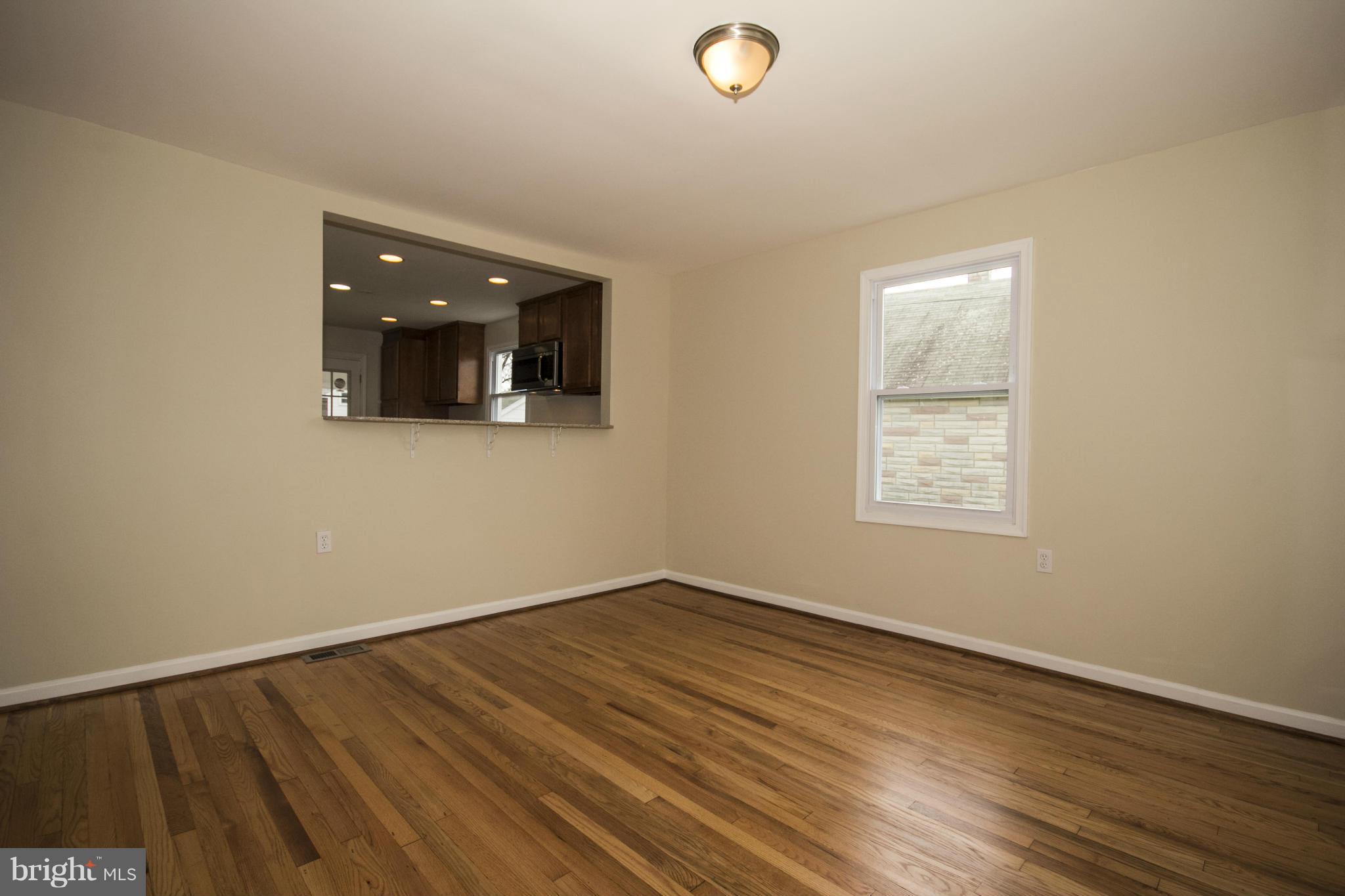 1220 Willow Road Baltimore, MD 21222 - Photo 8 of 23 an empty room with wooden floor and windows