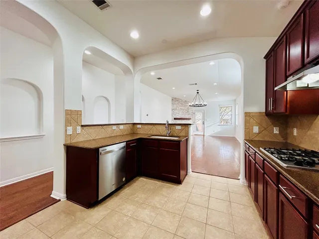 a kitchen with stainless steel appliances granite countertop a stove and a refrigerator