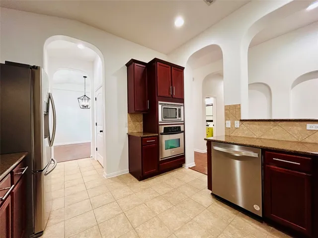 a kitchen with stainless steel appliances granite countertop a refrigerator and a stove